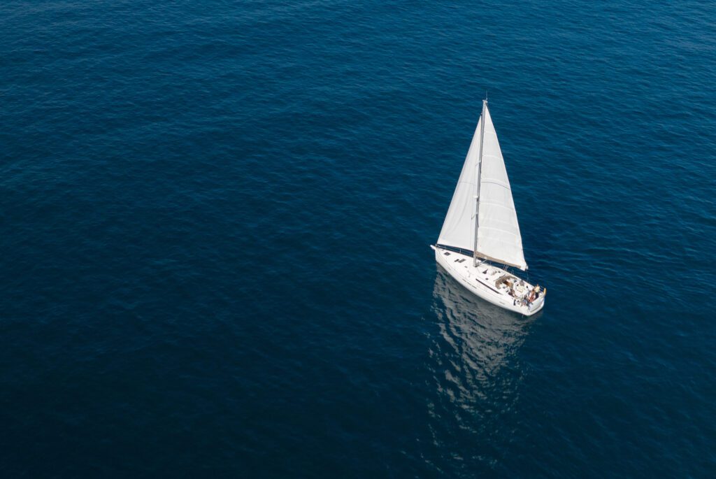 image of white sailing yacht in the blue sea top view