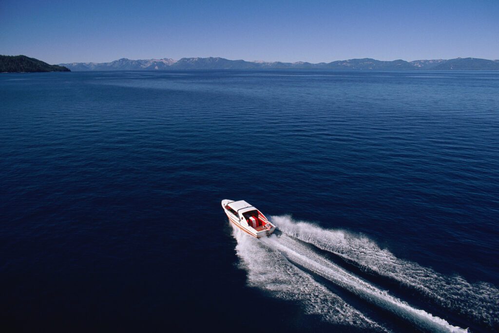 Distant shot of motorboat speeding across lake